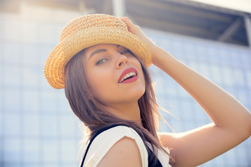 Beautiful woman walking, modern building in background, lens flare