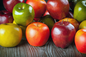Red apples on wooden table close up front view