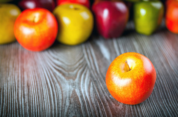Red apples on wooden table close up front view