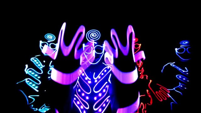 4 people dancing in costumes of LEDs 