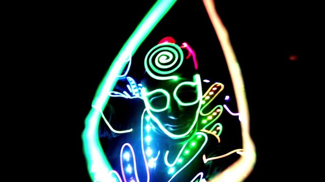 4 people dancing in costumes of LEDs 