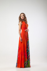 Blonde woman in bright dress with arms on waist