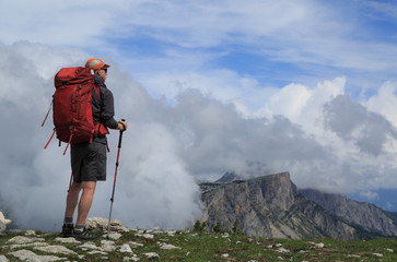 Hiker looking at the clouds over the mountains during an outdoor adventure.