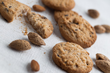 Cookies pile with chocolate chip and almond on light textile background. Delicious morning snacks for breakfast, brunch and lunch. Appetizing, healthy and fast food
