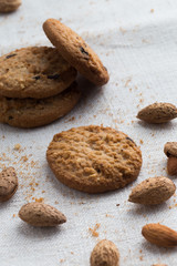 Cookies pile with chocolate chip and almond on light textile background. Delicious morning snacks for breakfast, brunch and lunch. Appetizing, healthy and fast food
