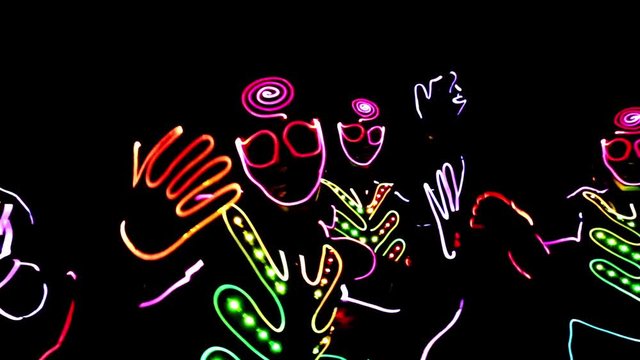 4 people dancing in costumes of LEDs 