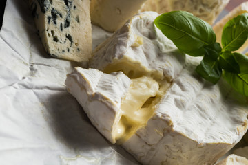Cheese assorted on a table background. Variety sorts for appetizing, gourmet, delicious snacks. Traditional French dish for wine on lunch and dinner closeup. Camembert, Roquefort.
