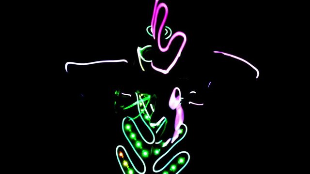 4 people dancing in costumes of LEDs 