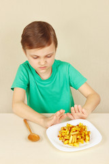 Little boy does not want to eat a french fries