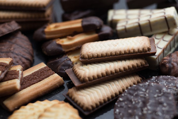 Cookies assorted on black background. Delicious morning snacks for breakfast, brunch and lunch. Appetizing, sweet and fast food.
