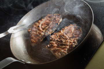 Steak cooking on grille pan. Fresh, delicious, spicy meat on a kitchen with copy space closeup