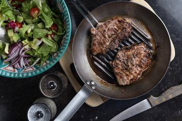 Steak cooking on grille pan. Fresh, delicious, spicy meat on a kitchen with copy space closeup