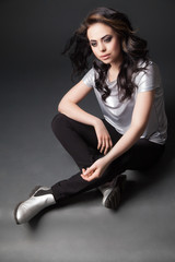 Woman with windy hair sitting on floor in studio