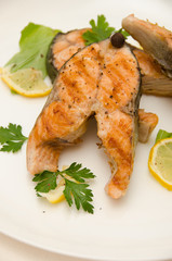 several salmon steaks round plate spices