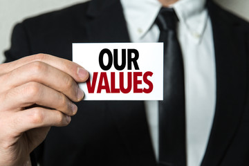 Business man holding a card with the text: Our Values