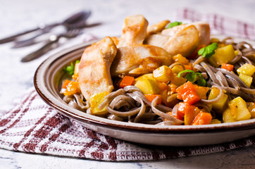 Dark pasta with vegetables and chicken.