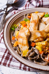 Dark pasta with vegetables and chicken.