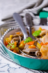Dark pasta with vegetables and chicken.