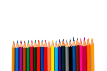 Row of color pencil placed on white background