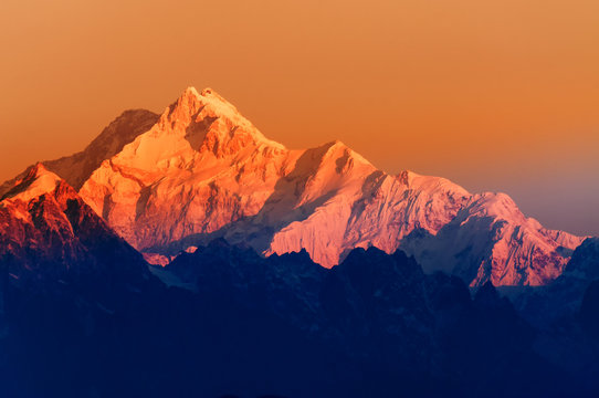 Fototapeta Beautiful first light from sunrise on Mount Kanchenjugha, Himalayan mountain range, Sikkim, India. Orange tint on the mountains at dawn.