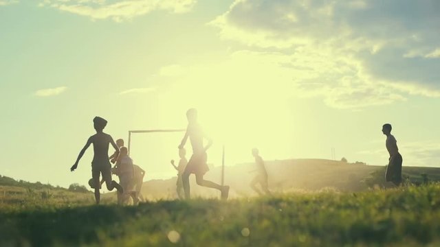 Boys are playing football game in the midle of the field. Slow motion.