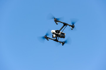 Flying drone with camera/Drone with camera hovering in blue sky