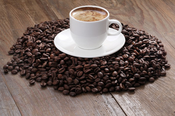 Coffee cup and coffee beans on a wooden table