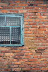 old blue window in a brick house