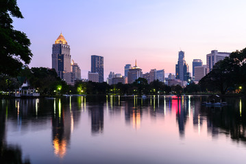 Bangkok skyline and water reflection with urban lake in summer.