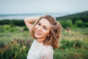 beautiful girl in white dress lies in green grass