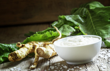 Ground horseradish, hot sauce to the food in a white bowl, roots
