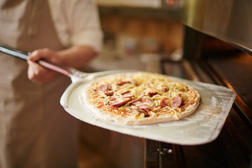 Pizza in den Ofen schieben
