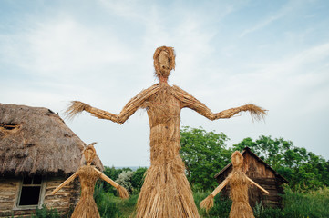 large handmade doll amulet near a wooden house