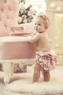 Kid baby girl in pink clothes and happy interior