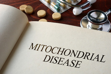 Book with diagnosis mitochondrial disease  and pills. Medical concept.