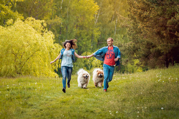 Obraz premium Young couple with the dogs in the park.