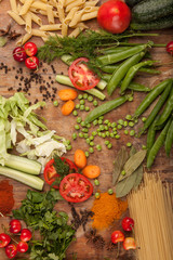 Vegetables and pasta on wood background. Bio Healthy food, herbs and spices. Organic vegetables