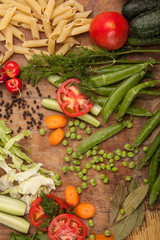Vegetables and pasta on wood background. Bio Healthy food, herbs and spices. Organic vegetables