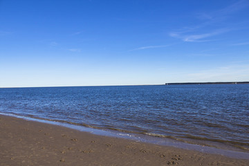 Beach in Broughty Ferry, Dundee, Scotland. Beautiful blue sky and sailboats on the horizon.