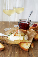 Baked camembert with toast and white wine in the background 