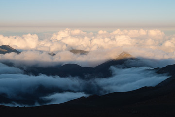 Obraz premium Warm and cold colors in the sunset over Haleakala with the cloud deck below the view point 