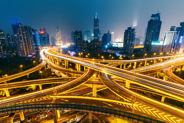View over the famous highway intersection in Shanghai, China, with illuminated highways and modern architecture. Shanghai skyline by night.