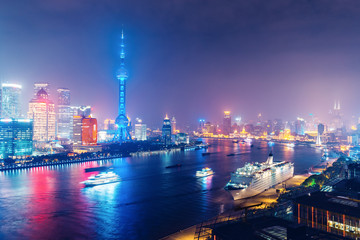 Aerial panoramic view over a big modern city by night. Shanghai, China. Nighttime skyline with illuminated skyscrapers.
