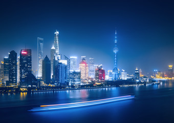 Big modern illuminated city by night. Shanghai, China. Nighttime skyline with skyscrapers and the Hunapu river.