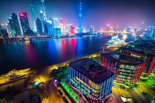 Aerial panoramic view over a big modern city by night. Shanghai, China. Nighttime skyline with illuminated skyscrapers.