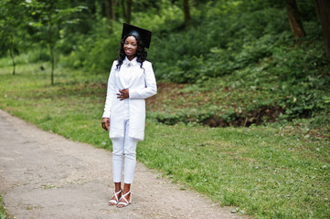 Happy beautiful black african american girl with hat graduates