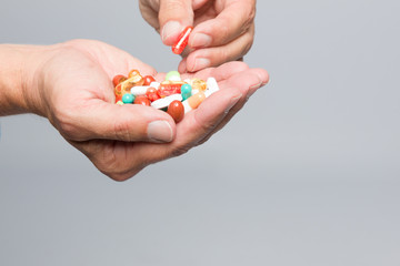 Zwei Hände mit einer Menge bunter Tabletten
