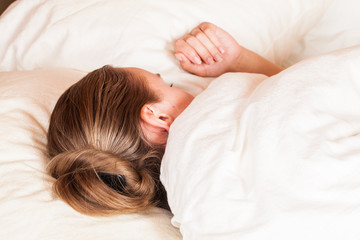 Beautiful young woman sleeping in bed. Toned photo.