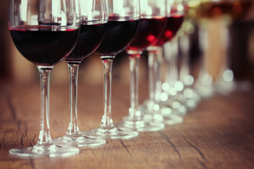 Many glasses of different wine in a row on bar counter