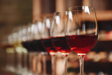Many glasses of different wine in a row on bar counter